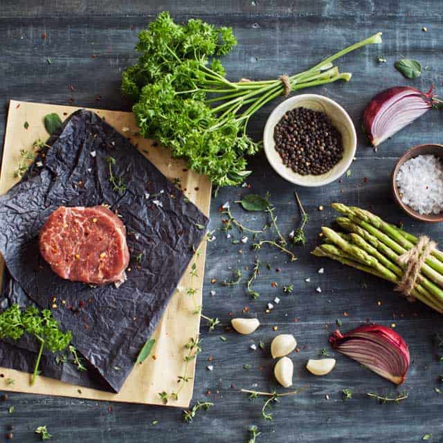 Paleo diet foods-meats and veggies on brown wood