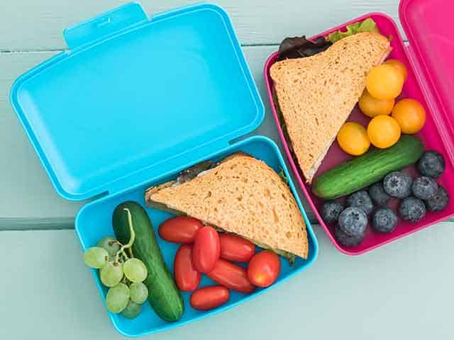 Bento-box-style snack boxes with fruit, vegetables and sandwiches.