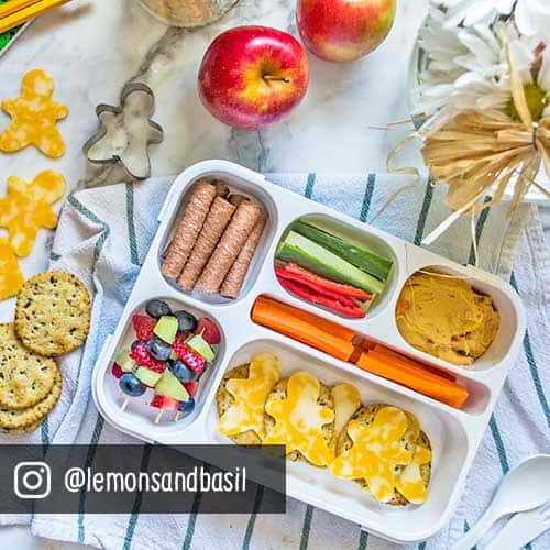 crackers, fruit, vegetables and cheese in a lunch box