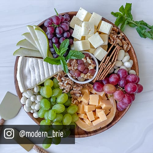 charcuterie board with cheese and seasonal grapes