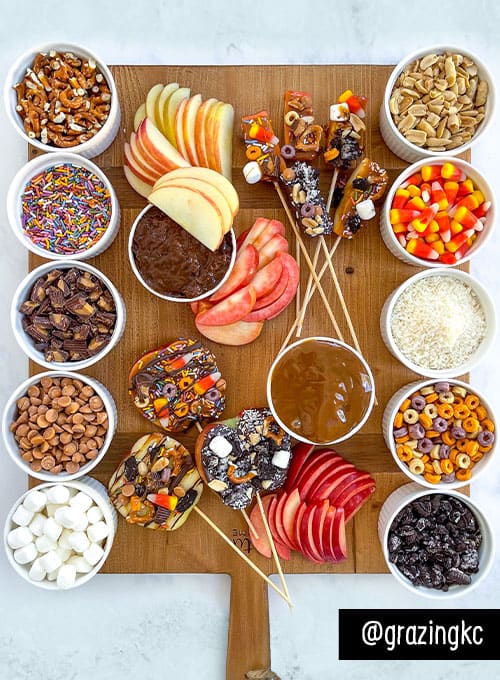 Caramel apple board with bowls of toppings